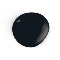 A droplet of Liberation Nails 21-free black nail polish in a classic black color, Blackbird.