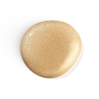 A droplet of Liberation Nails shimmery gold nail polish, Gilded Mystic