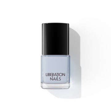 A bottle of Liberation Nails nail polish in a soft, cool gray color, Stormproof.