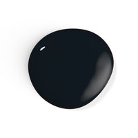 A droplet of Liberation Nails 21-free nail polish in a classic black color, Blackbird.