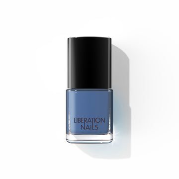A bottle of Liberation Nails nail polish in an azure blue color, Indigo Child.