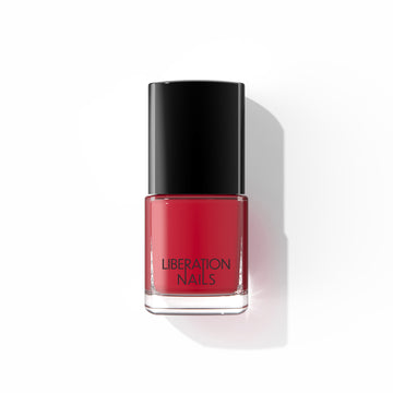 A bottle of Liberation Nails nail polish in a cool-toned red color, Looker.