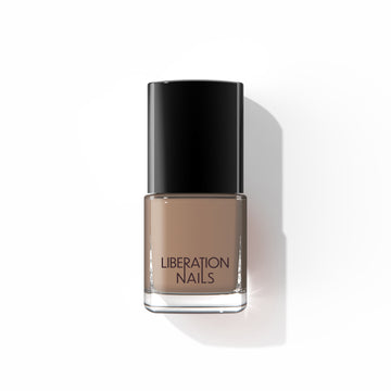 A bottle of Liberation Nails nail polish in a soft light brown color, Temple.